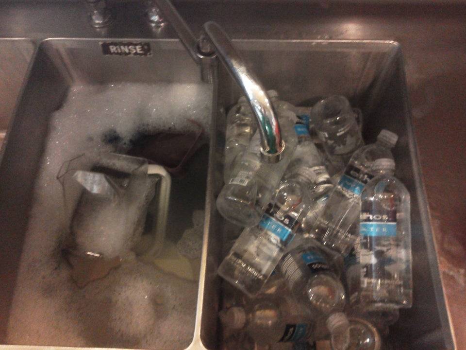 Kitchen sink filled with bottles of water