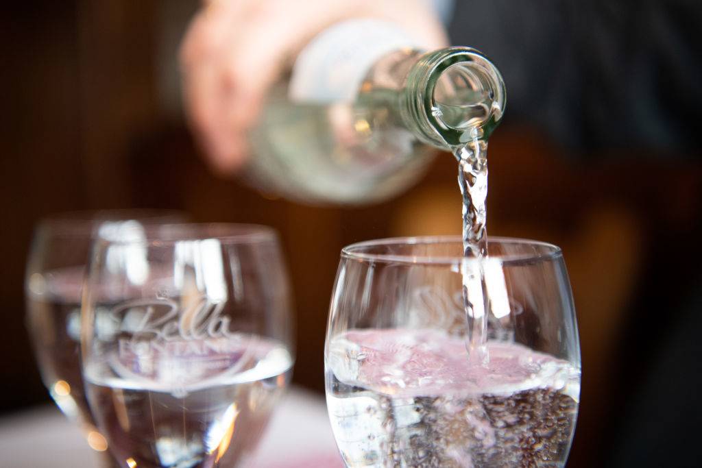 someone pouring water into a glass