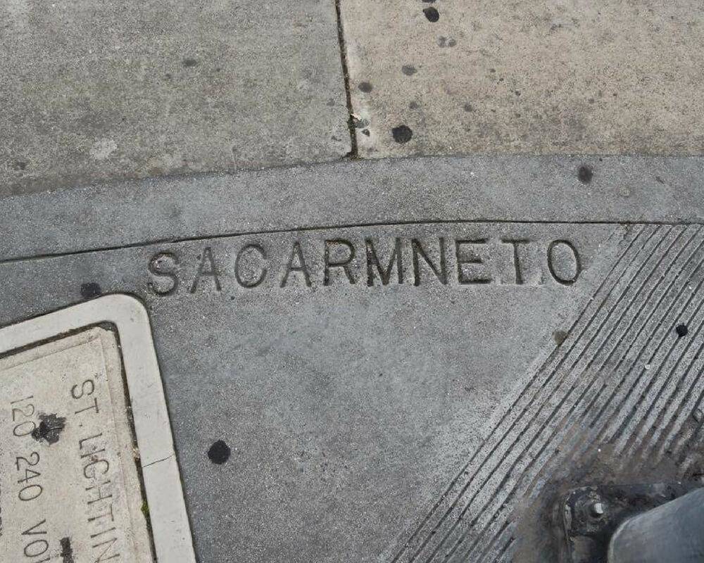 city man hole cover reads 'Sacarmneto'