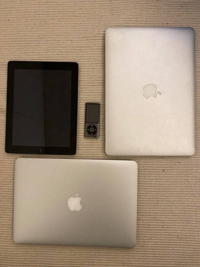 Apple laptops, iPod and a tablet on the ground.