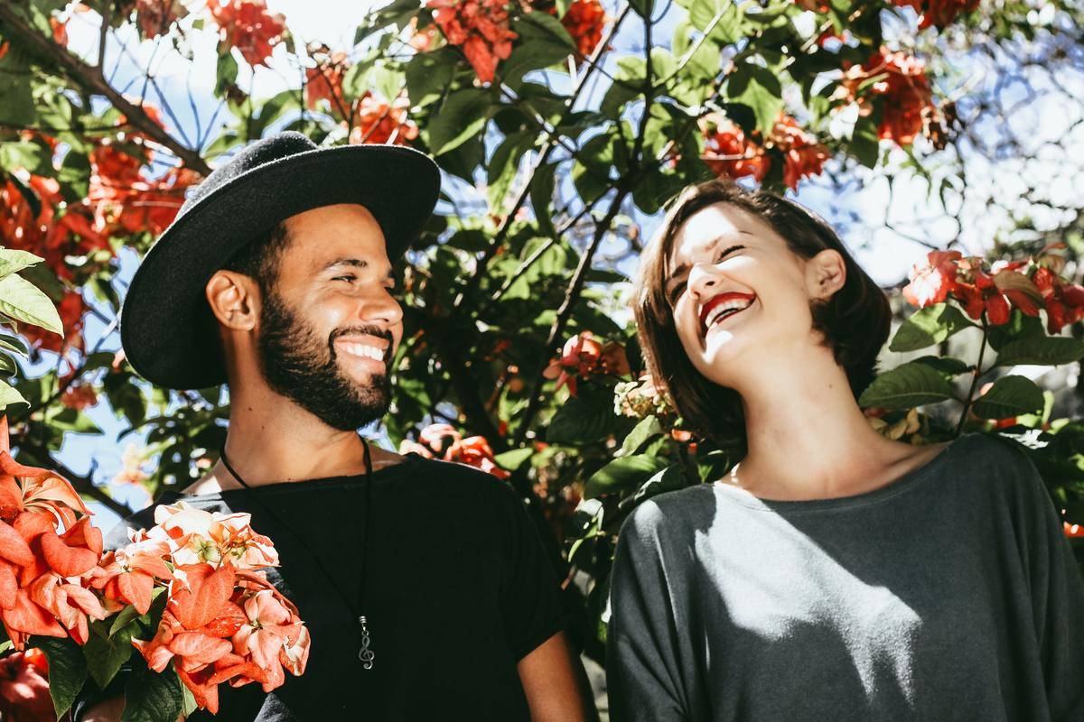 People laugh outside in tree that is blooming flowers