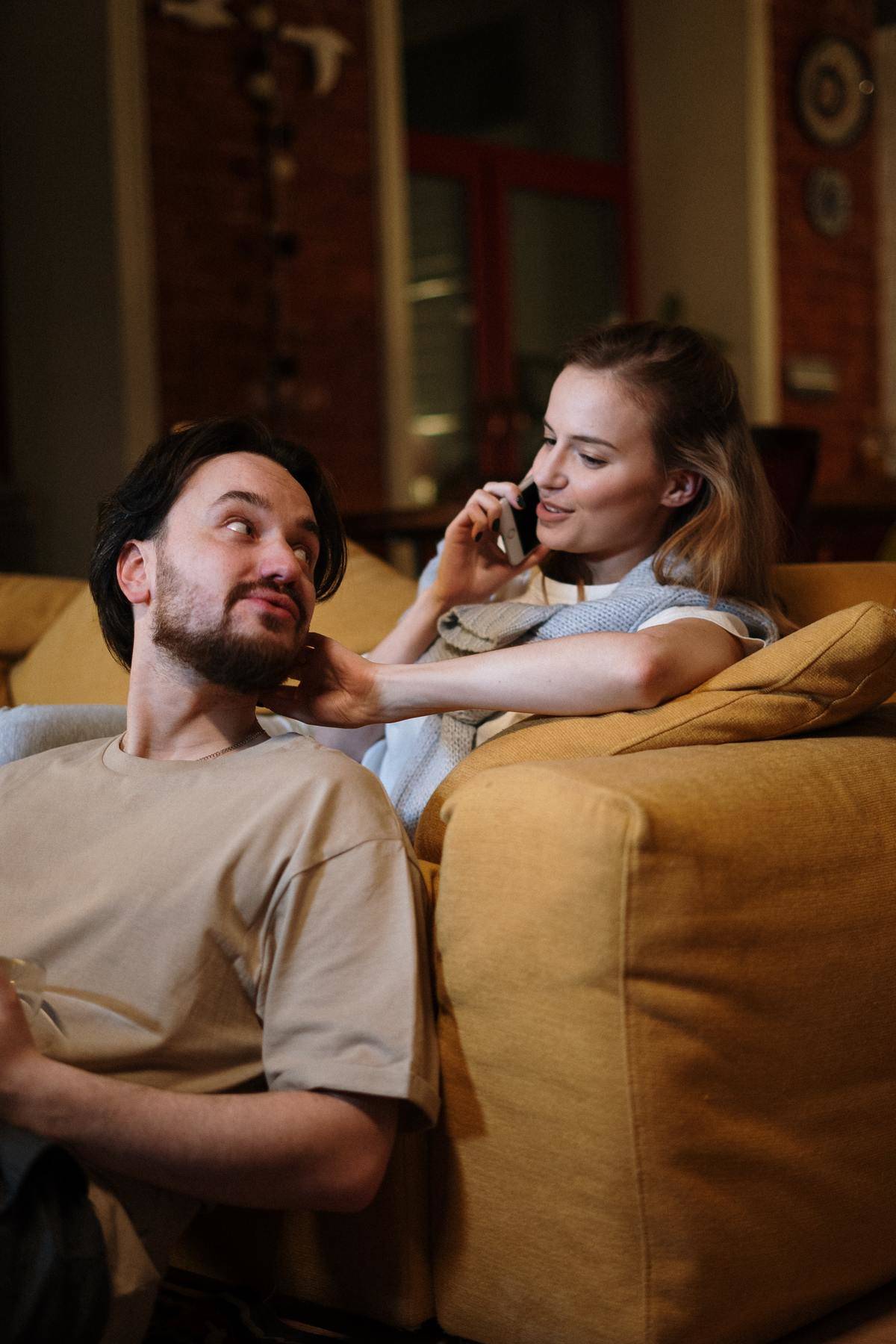 Couple sits on couch at home together