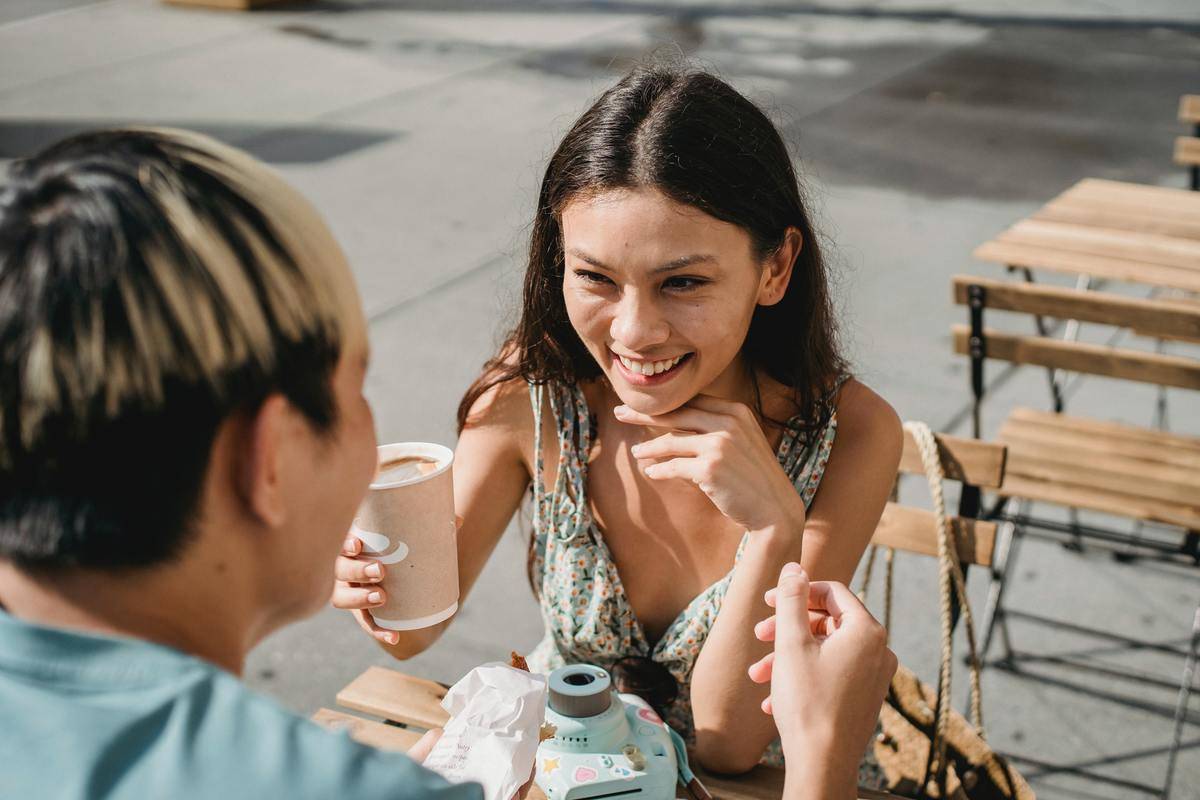 Girl laughing with hand on chin on date