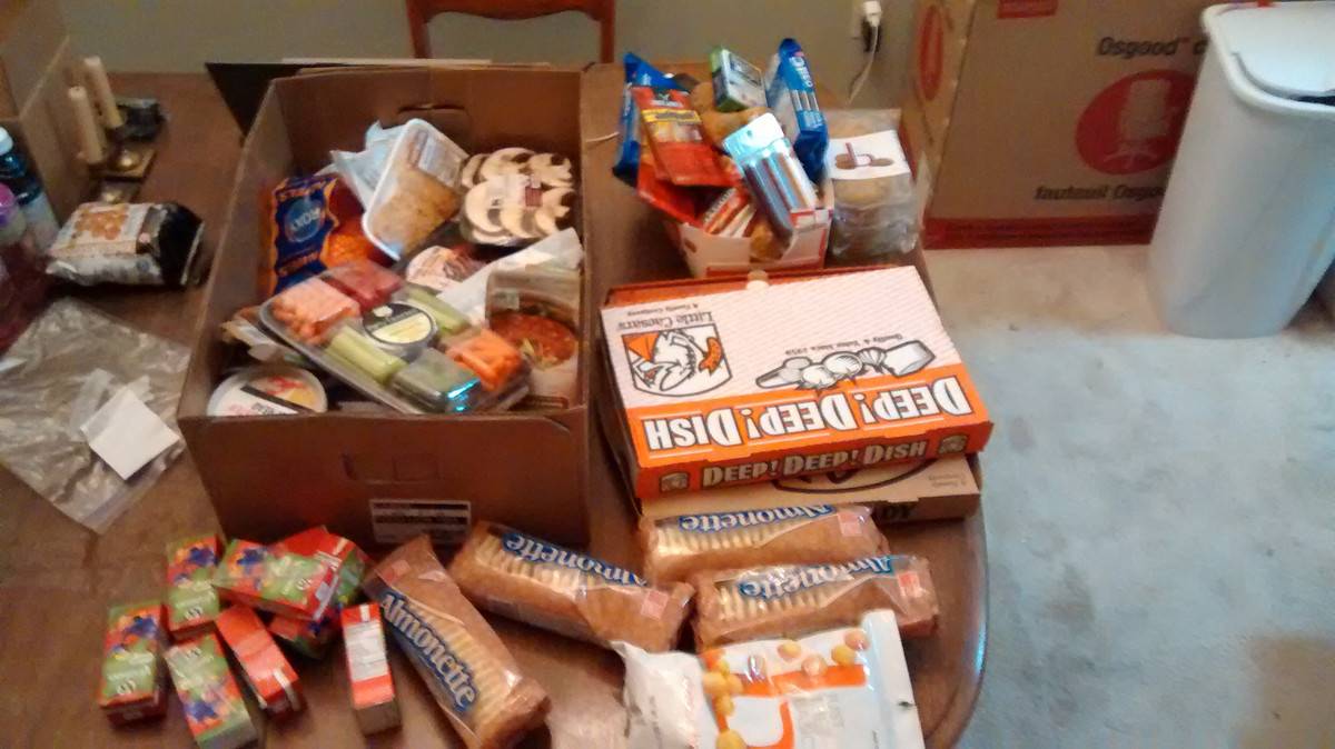 Boxes of pizza and crackers and snacks on a table.