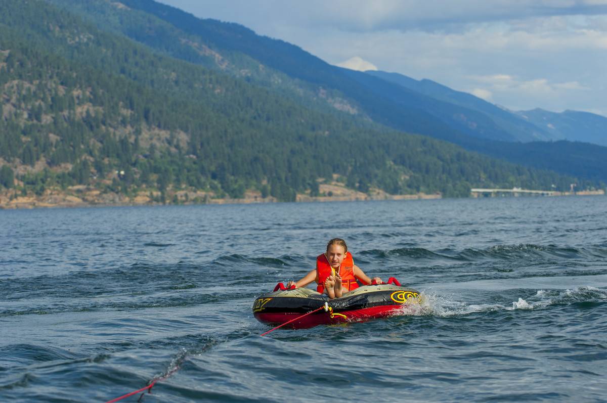 A teenager (model released) is inner tubing on Lake Pend...