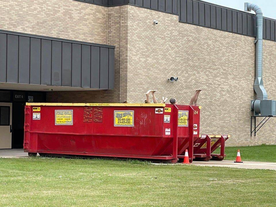 feet in the air in a dumpster