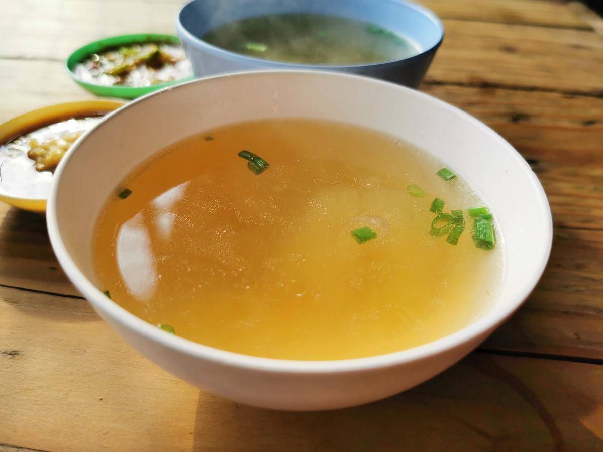 A bowl of golden-colored broth.