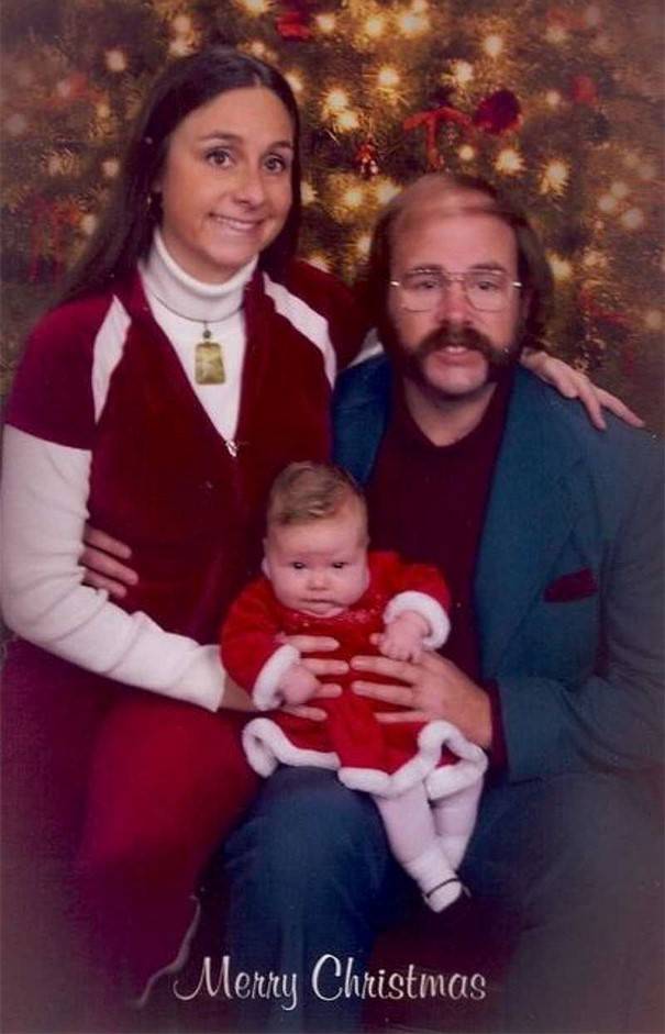 Christmas card from a mom, dad, and baby all with a pained expression on their face.