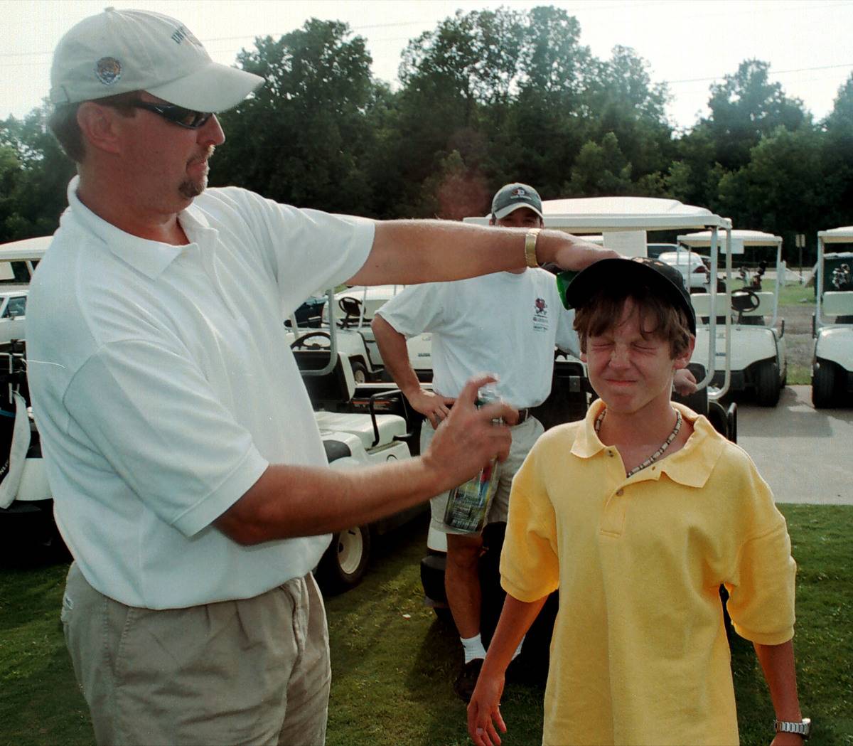 A father sprays his son with mosquito repellent in order to prevent the spread of West Nile virus in Louisiana.