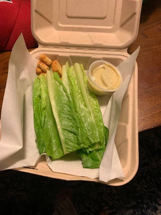 Takeout salad from local restaurant is just romaine lettuce, uncut, with side caesar dressing and 5 croutons