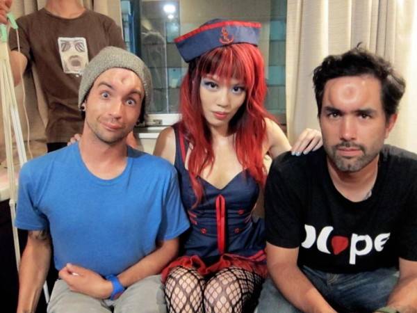 TV organizer La Carmina between two men with bagel heads (injections in their foreheads)