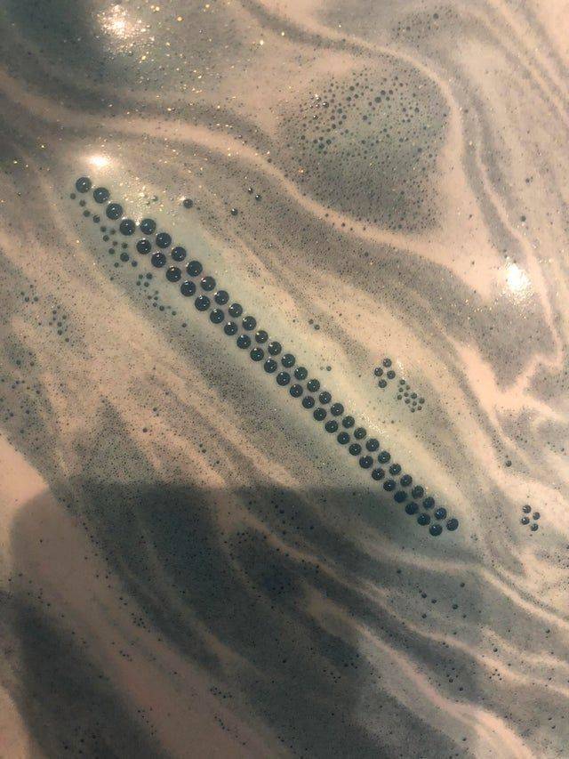 long line of lined up bubbles on surface of water