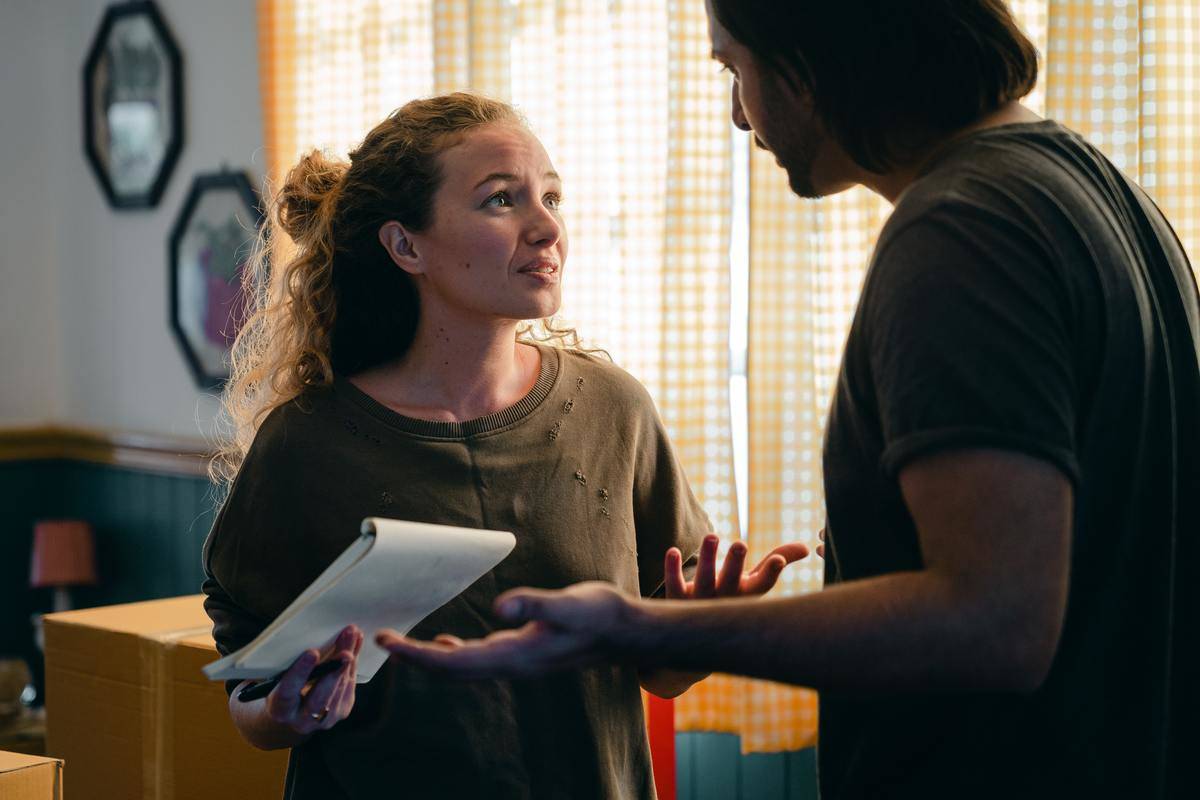 Woman holds a notebook and has a fight with a man.
