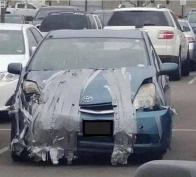 Lots of duct tape holding up the bumper of a car. 