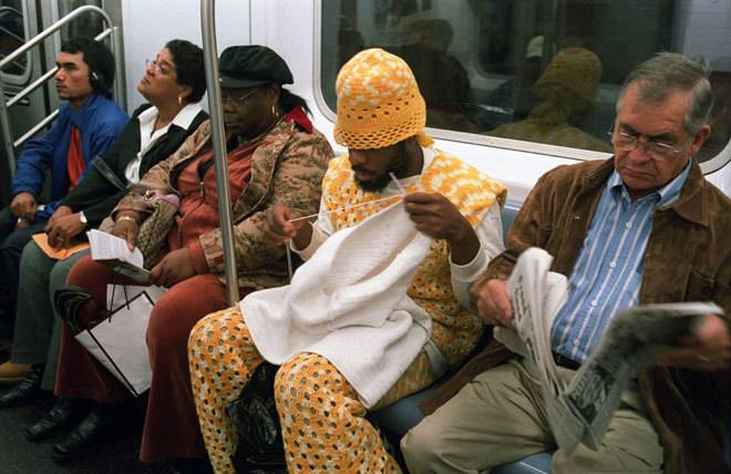 Man wearing full knit crocheted outfit on subway making something new