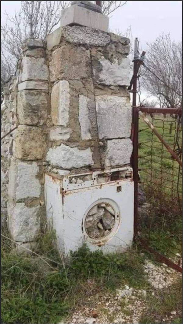 Washing machine used as a base for a concrete pillar. 