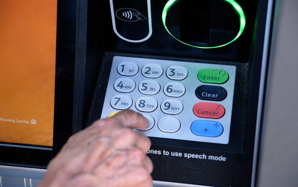 A banking customer uses an ATM machine