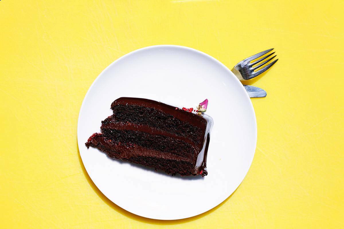 german chocolate cake slice on a plate with fork and yellow background