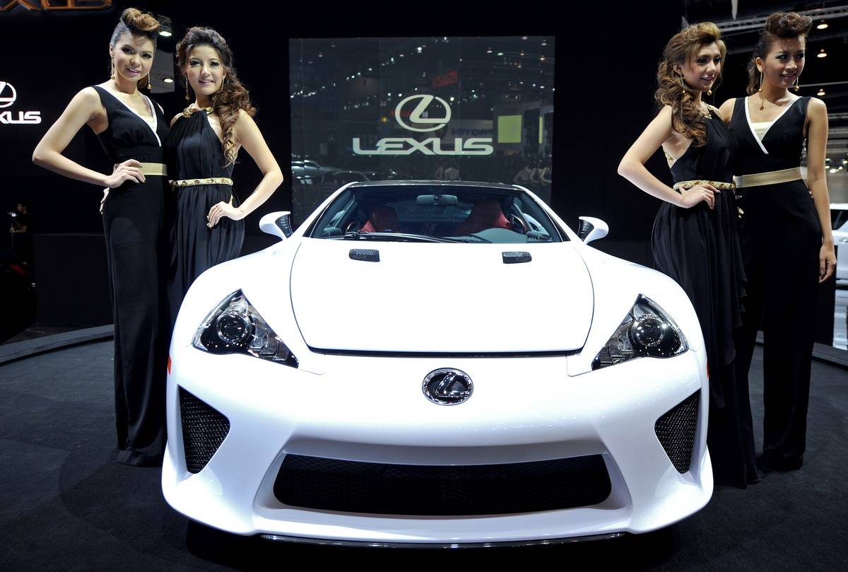 Models pose beside the new Lexus LFA dis