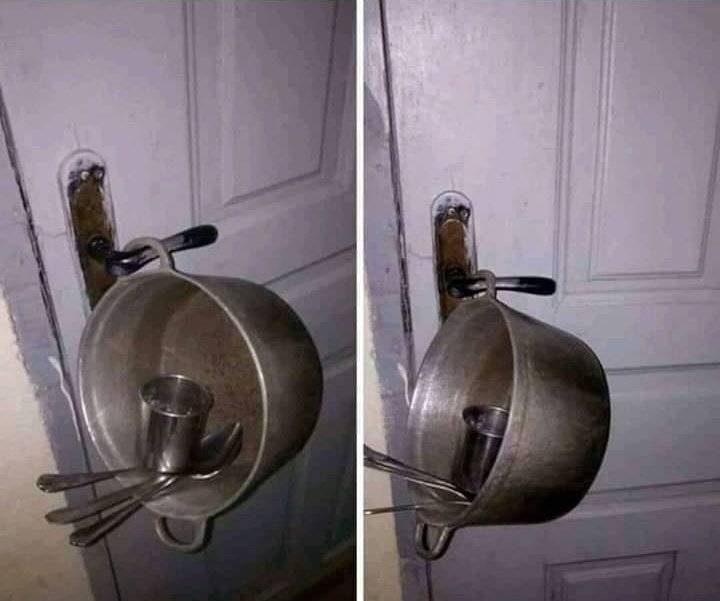 Pot with spoons in it hanging off of a door handle 