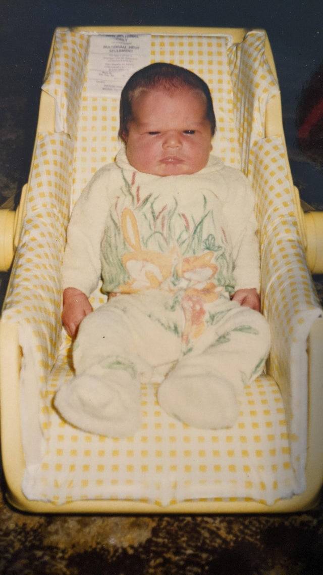 Girlfriend discovers photo of her boyfriend as a baby in which he is scowling. 