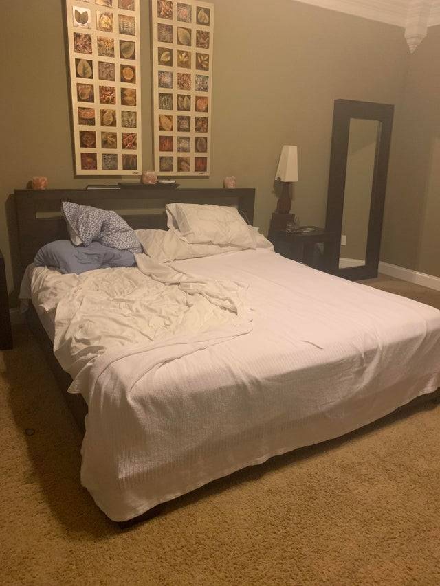 A bed where only half of it is made.