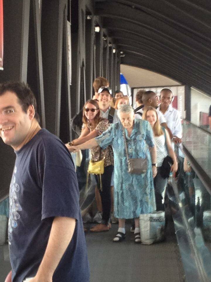 French elderly woman blocking moving runway at airport