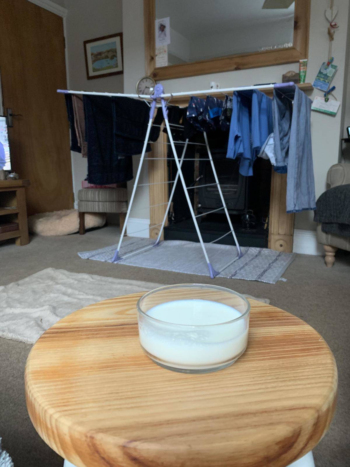 Bowl of milk in glass baking dish sitting on a wooden stool
