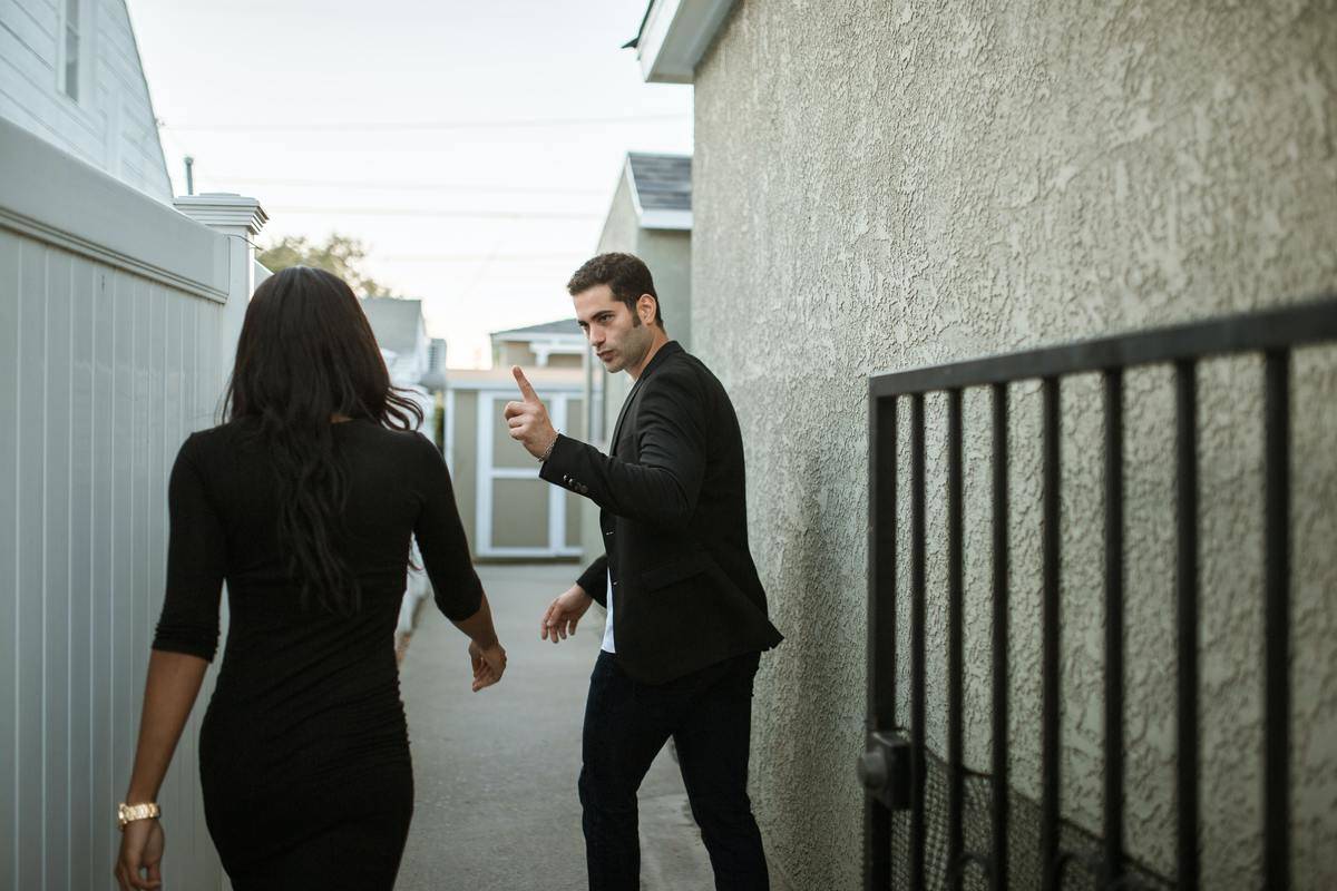 Couple in disagreement outside, man with finger pointed at woman