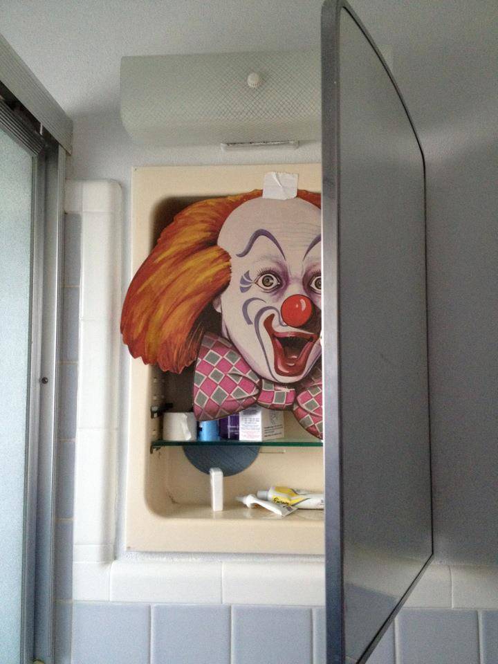 Clown mask in cabinet behind bathroom mirror