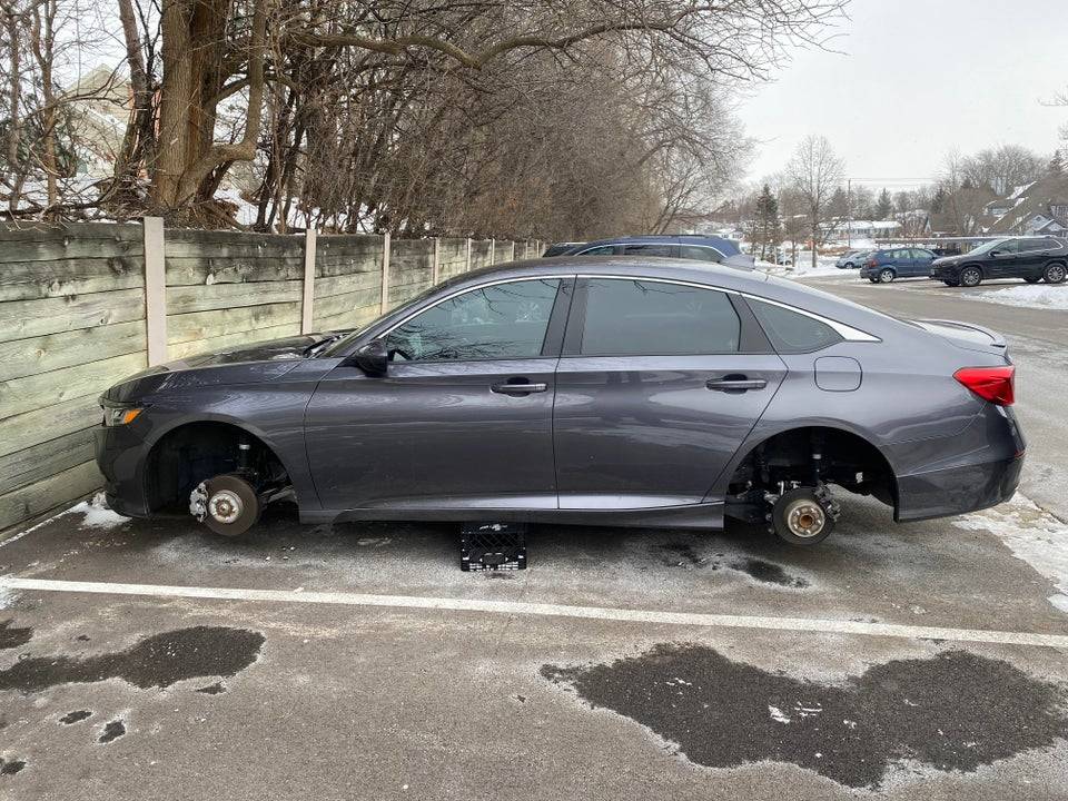 Gray car missing all four wheels