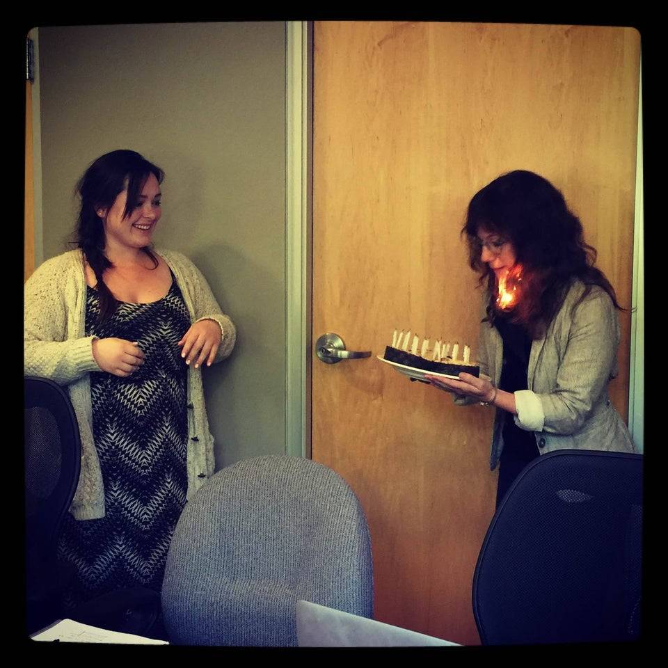 Woman holding a cake and her hair has caught fire. 
