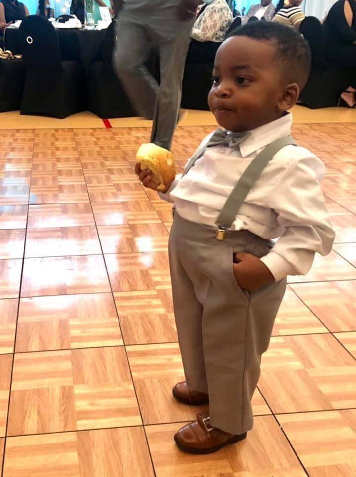 Young toddler dressed like classy gentleman at wedding event
