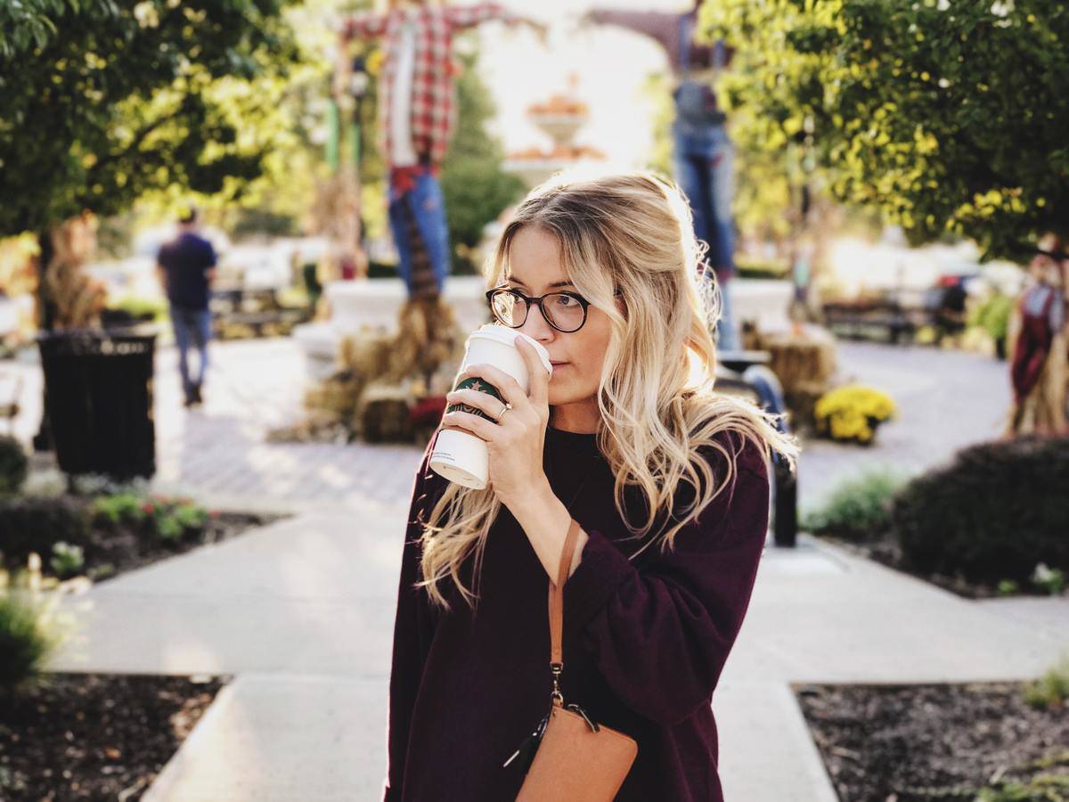Woman sipping coffee on city street