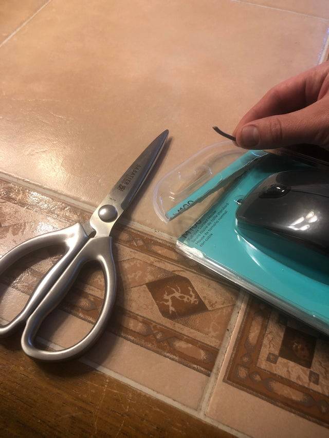 Man cut computer mouse package open and cut cord