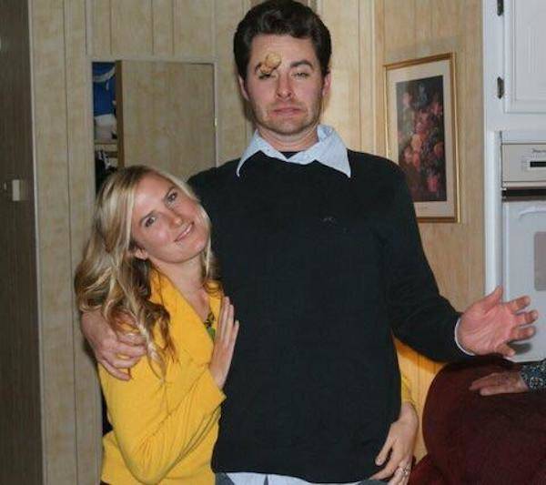 Man and woman posing for picture. Cork about to hit man in face.