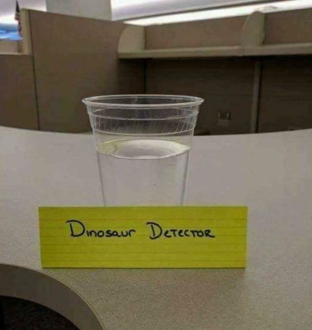 Cup of water with a dinosaur detector sign on it. 