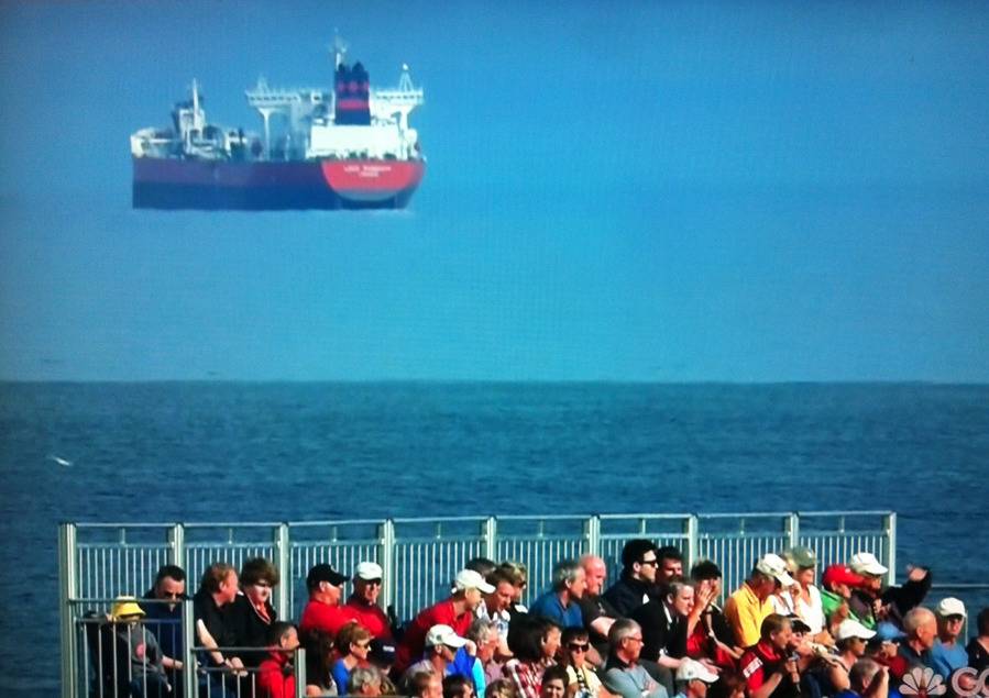 People on bleachers and a ship that looks like it is floating in the sky.