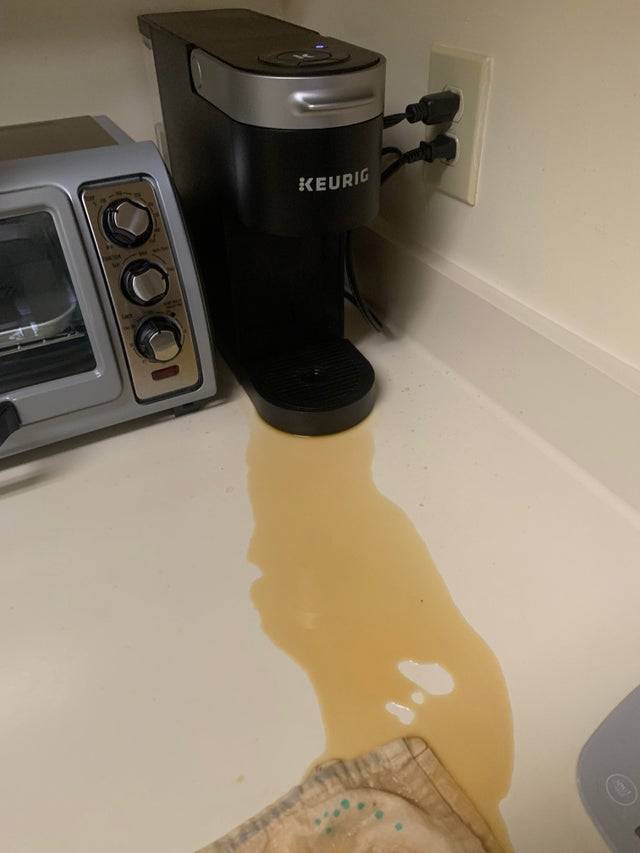 Keurig machine with coffee spilled onto the counter. 