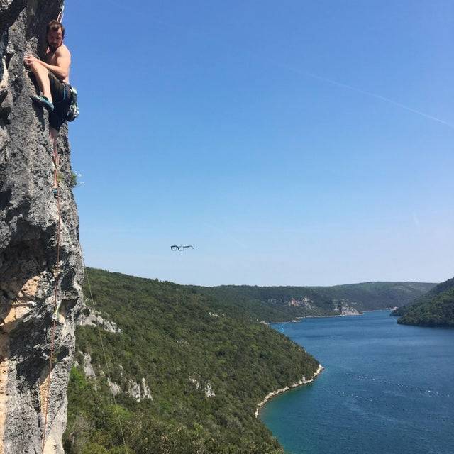 Person rock climbing and glasses falling. 