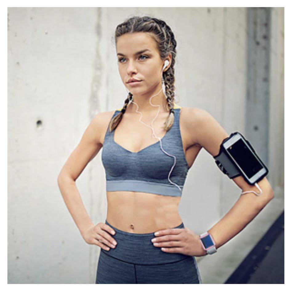 Woman in workout clothes wearing headphones that don't attach to anything.