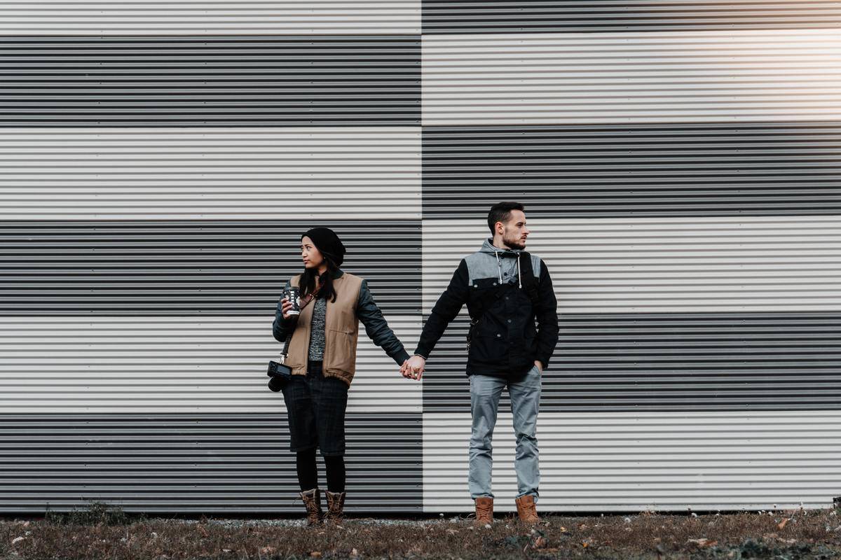 Couple holding hands looking opposite directions