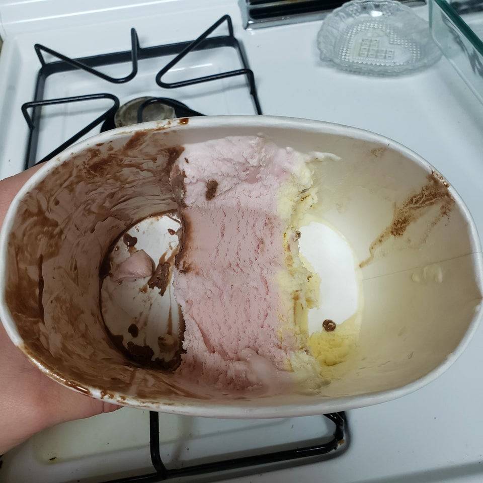 Tub of Neapolitan ice cream with chocolate and vanilla gone