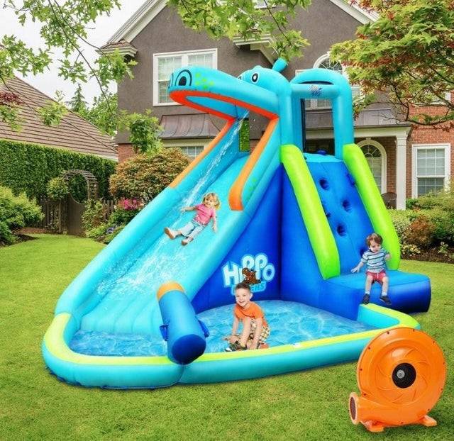Inflatable waterslide with kids on it in full clothing
