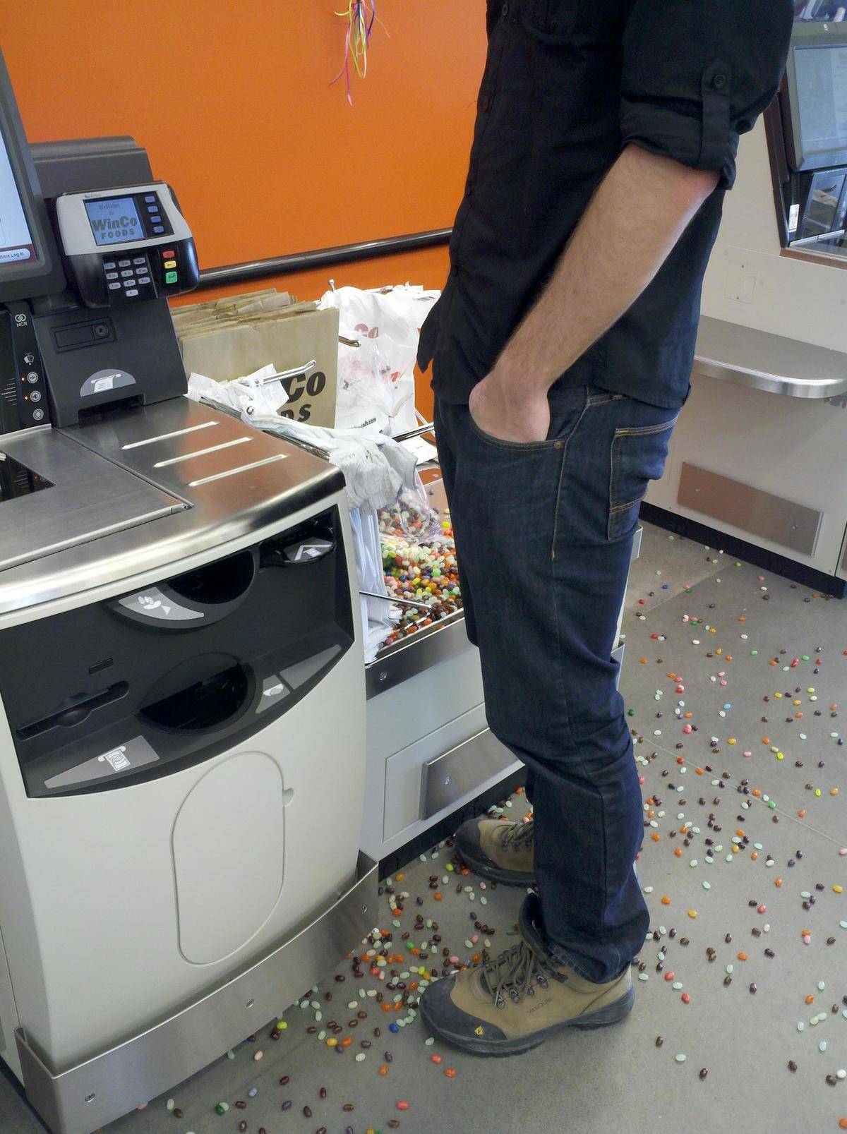 A person standing beside jelly beans that have spilled all over the ground