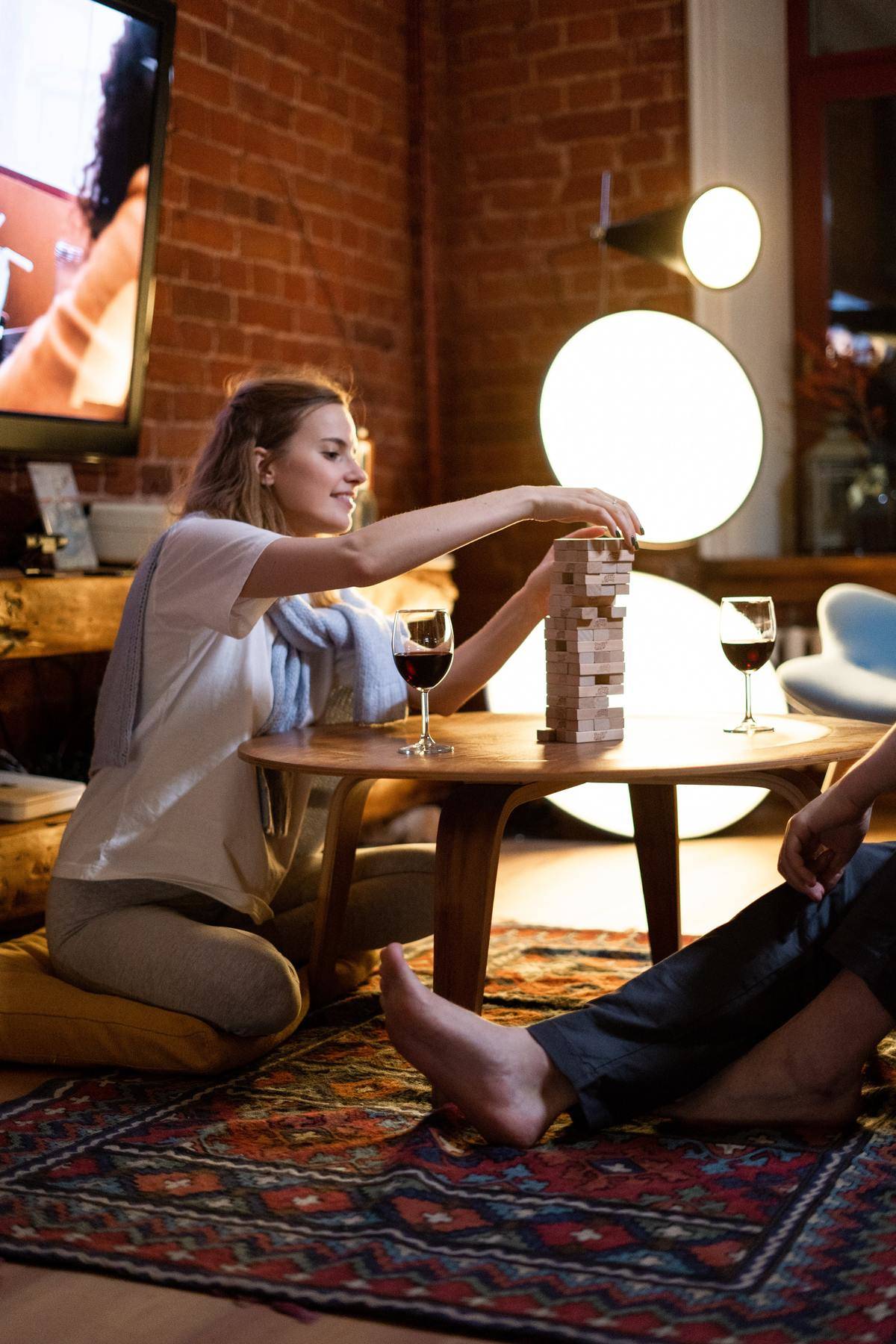 Woman plays Jenga while seated on floor