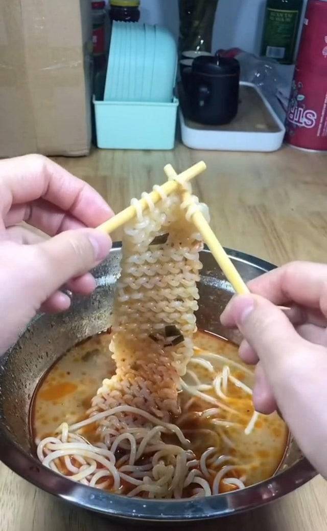 Person knitting ramen noodles with chopsticks