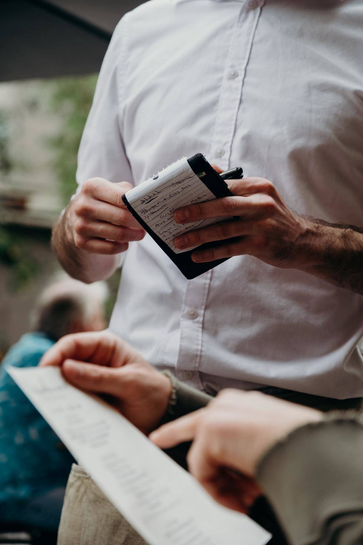 Hand holding and pointing at a large restaurant bill
