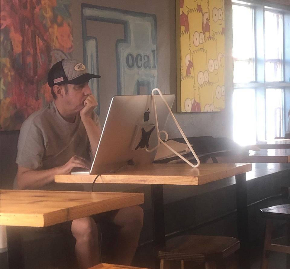 Man uses plastic coat hangar as Mac monitor stand