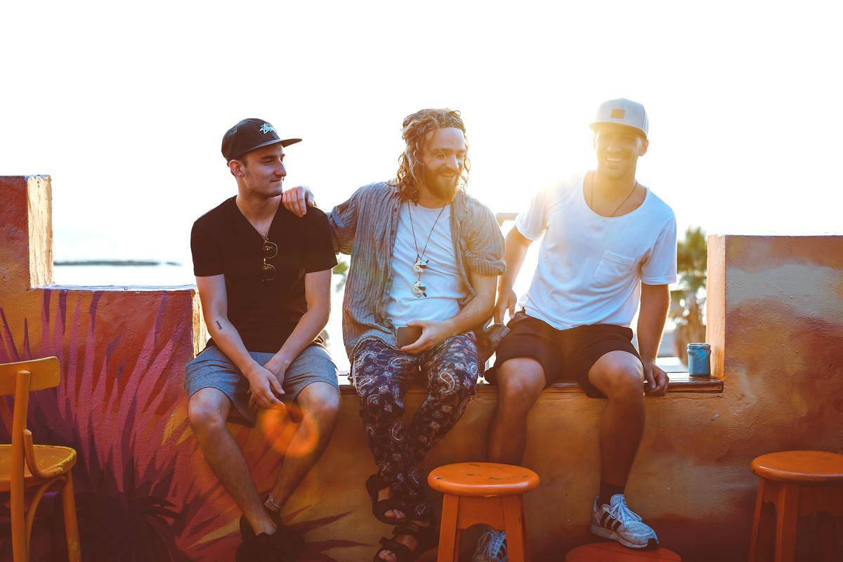 Three men hang out on outdoor patio